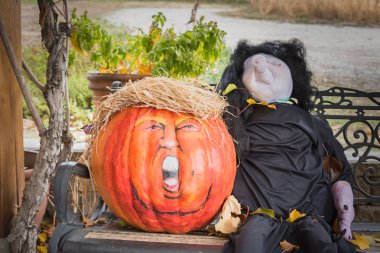 Penticton, British Columbia/Kanada - 31 Ekim 2017: ABD Başkanı Donald Trump'a benzemek için süslenmiş balkabağıyla açık bir bankta mizahi hallowe'en gösterisi