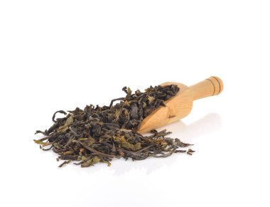 Kuru yeşil çay yapraklarının üzerine tahta kaşık.