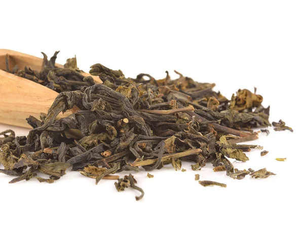 Деревянная ложка на сухих зеленых чайных листьях — стоковое фото
