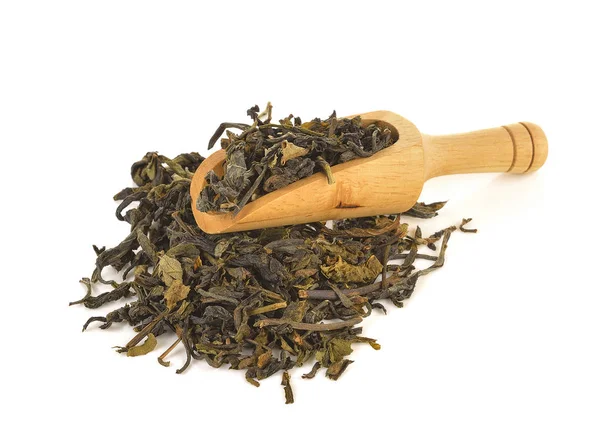 Деревянная ложка на сухих зеленых чайных листьях — стоковое фото