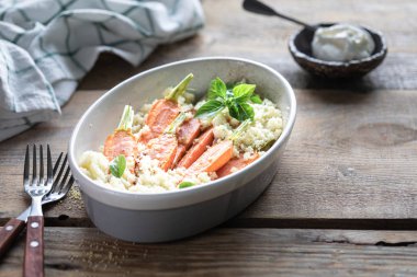 Pravanese otlar ile pişmiş genç havuç. kuskus Ekşi krema, yoğurt veya taze krema.