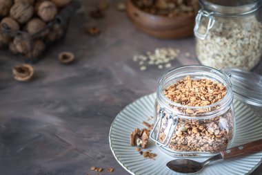 Sağlıklı kahvaltı için cam kavanozda fındık ve çekirdekli ev yapımı granola.