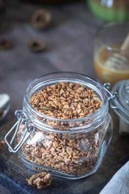 Sağlıklı kahvaltı için cam kavanozda fındık ve çekirdekli ev yapımı granola.