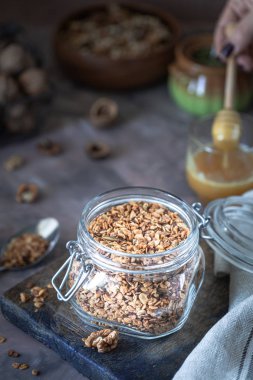Sağlıklı kahvaltı için cam kavanozda fındık ve çekirdekli ev yapımı granola.