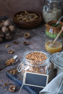 Sağlıklı kahvaltı için cam kavanozda fındık ve çekirdekli ev yapımı granola.