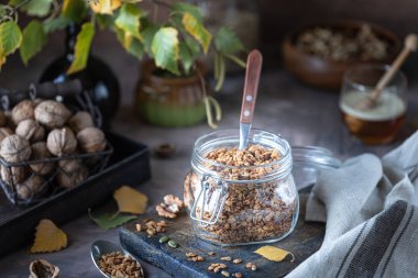 Sağlıklı kahvaltı için cam kavanozda fındık ve çekirdekli ev yapımı granola.