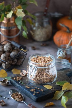 Sağlıklı bir kahvaltı için cam bir kavanozda fındık ve tohum ile ev yapımı kabak müsli. Sonbahar natürmort