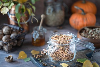 Sağlıklı bir kahvaltı için cam bir kavanozda fındık ve tohum ile ev yapımı kabak müsli. Sonbahar natürmort