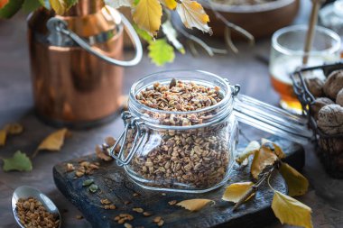 Sağlıklı bir kahvaltı için cam bir kavanozda fındık ve tohum ile ev yapımı kabak müsli. Sonbahar natürmort
