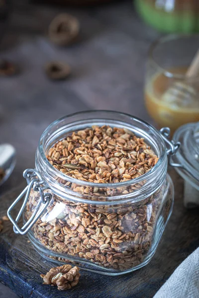 Sağlıklı kahvaltı için cam kavanozda fındık ve çekirdekli ev yapımı granola.