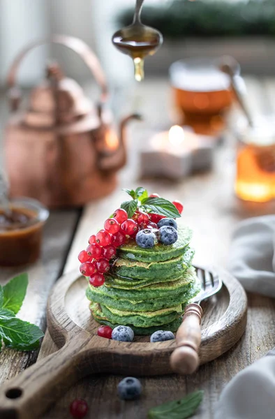 Panquecas de espinafre doce com groselhas e mirtilos e mel . — Fotografia de Stock