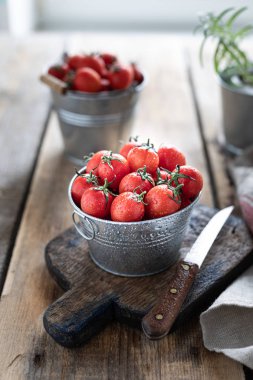 Sos için bir madde olarak kırmızı olgun kiraz domates bir grup. Ahşap bir masada