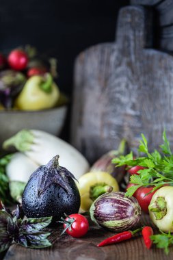 Ahşap bir masada farklı renk ve farklı sınıflarda patlıcanlar.