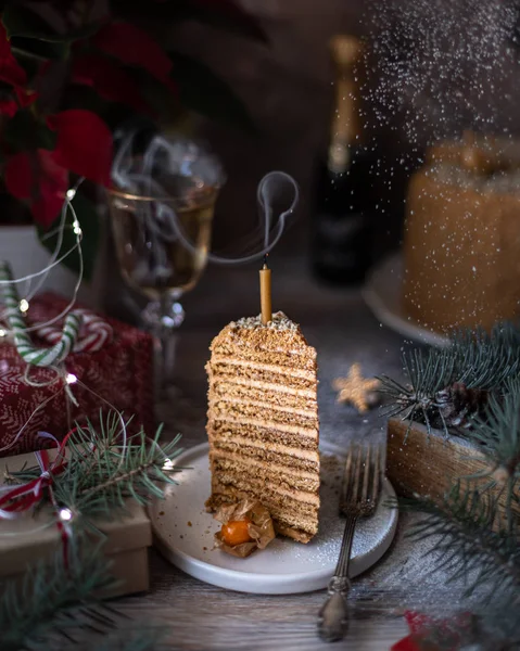 Homemade honey cake. Winter composition. New Year photo. Christmas decoration. Christmas decorations. Cake with sparklers. Candles. Snow.