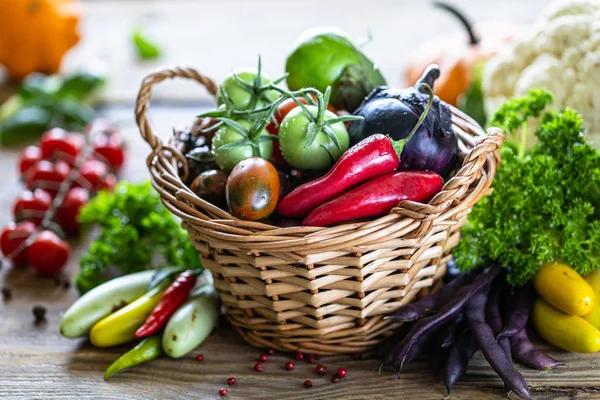 Φθινοπωρινή συγκομιδή λαχανικών σε ένα ψάθινο καλάθι: ντομάτες, φασόλια, κολοκύθα, λάχανο, χόρτα, μαϊντανός. — Φωτογραφία Αρχείου