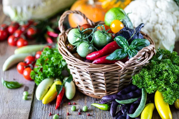 Φθινοπωρινή συγκομιδή λαχανικών σε ένα ψάθινο καλάθι: ντομάτες, φασόλια, κολοκύθα, λάχανο, χόρτα, μαϊντανός. — Φωτογραφία Αρχείου