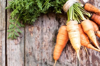 Hasır tepside organik havuç, ahşap arka planda üst manzara. Kırsal doğal stil. Boşluğu kopyala