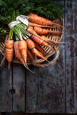 Hasır tepside organik havuç, ahşap arka planda üst manzara. Taşralı. Boşluğu kopyala