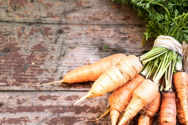 Hasır tepside organik havuç, ahşap arka planda üst manzara. Kırsal doğal stil. Boşluğu kopyala