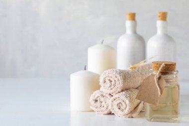 Beyaz arka planda gerekli yağ, mumlar ve havlular. Spa ve sağlık konsepti