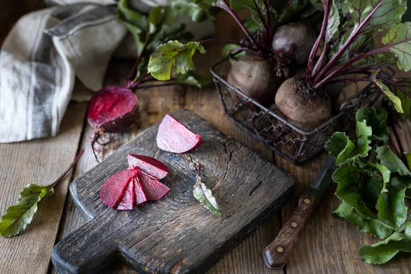 Świeże organiczne czerwone buraki z liśćmi w wiklinowym koszu na drewnianym stole. Naturalne organiczne warzywa. Jesienne zbiory. Rustykalny — Zdjęcie stockowe