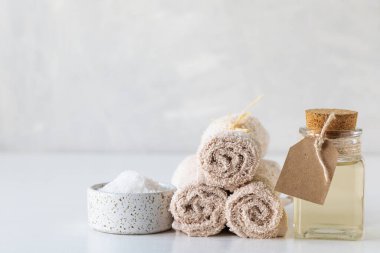 Beyaz arka planda banyo tuzu ve havlularla yağlı spa konsepti. Spa ve sağlık hala hayat.