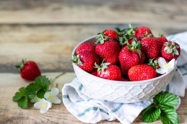 Ahşap arka planda bir kase çilek. Boşluğu kopyala