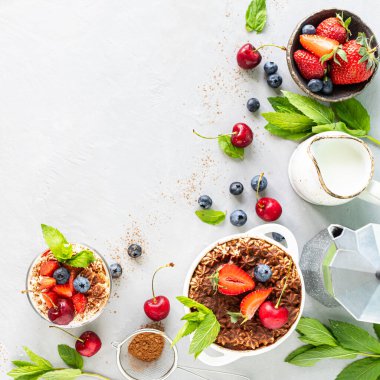 Tiramisu İtalyan tatlısı ve yemek malzemeleri. Kahve, kakao, çilek, beyaz arka planda nane şekeri. Üst görünümü kopyala.