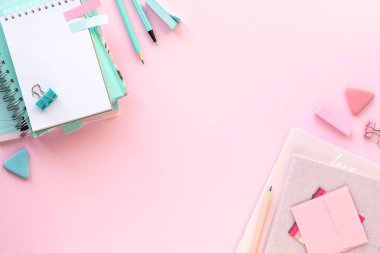 Okul ve ofis için kopyalanmış pembe zemin üzerine çeşitli renkli kırtasiye malzemesi