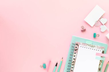 Okul ve ofis için kopyalanmış pembe zemin üzerine çeşitli renkli kırtasiye malzemesi