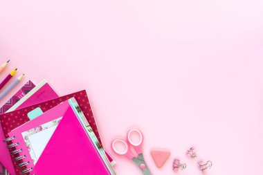 Okul ve ofis için kopyalanmış pembe zemin üzerine çeşitli renkli kırtasiye malzemesi