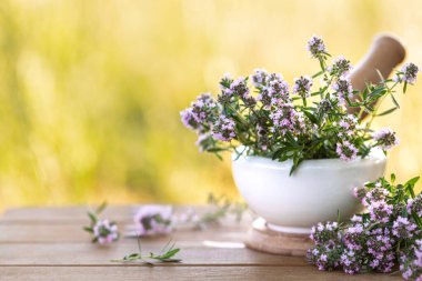 Doğanın arka planına karşı ahşap bir masada bir demet taze kekik..