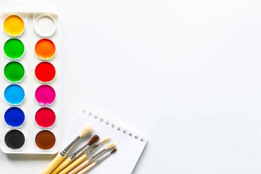 Fotokopi alanı olan beyaz bir arkaplanda resim yapmak için renkli boyalar.