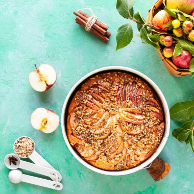 Yeşil taşlı arka planda elma ve malzemeli turta. Üst görünüm