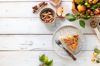 Beyaz ahşap arka planda ev yapımı elmalı turta ve malzemeler. Üst görünüm