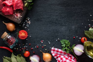 Çiğ biftek filetosu ızgara için hazır. Tahta kesme tahtasındaki dana filetosu, kiraz domatesleri, acı biber ve bitkilerle birlikte. Çorba ya da borç için malzemeler. kopyalama alanı. en üstteki görünüm