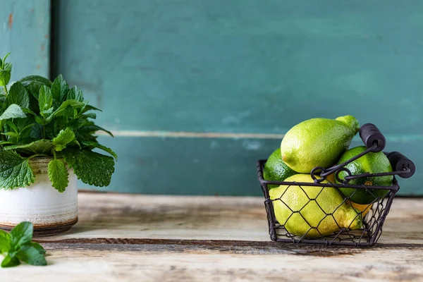 Fresh organic mint and lemon balm in a metal mug on a wooden table. Selective focus.