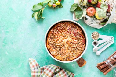 Yeşil taşlı arka planda elma ve malzemeli turta. Üst Manzara. Boşluğu kopyala.