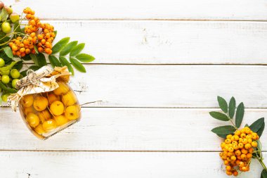 Sonbahar arkaplanı beyaz ahşap bir masada şekerli şuruplu cennet elmaları. Sonbahar hasadını hasat ediyorum. Cennet elma reçeli. Üst Manzara. Boşluğu kopyala.