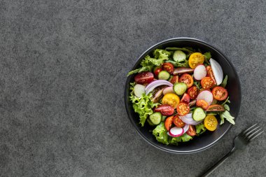 Siyah arka planda tabakta taze sebze salatası..