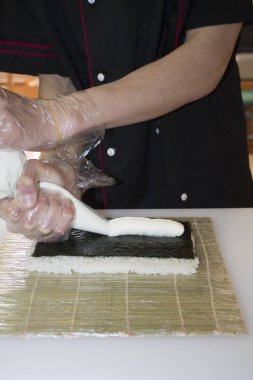 Ellerinizi kapatın. Şef bambu hasırında suşi yapıyor.