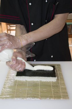 Ellerinizi kapatın. Şef bambu hasırında suşi yapıyor.