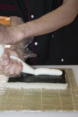 Ellerinizi kapatın. Şef bambu hasırında suşi yapıyor.