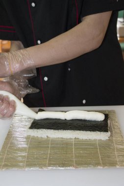 Ellerinizi kapatın. Şef bambu hasırında suşi yapıyor.