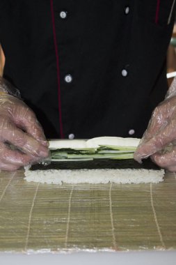 Ellerinizi kapatın. Şef bambu hasırında suşi yapıyor.