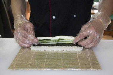 Şef bambu hasırında suşi yapıyor.