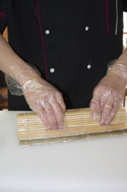 Şef bambu hasırla suşi yapıyor.