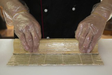 Şef bambu hasırla suşi yapıyor.