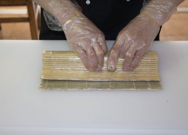 Şef bambu hasırla suşi yapıyor.