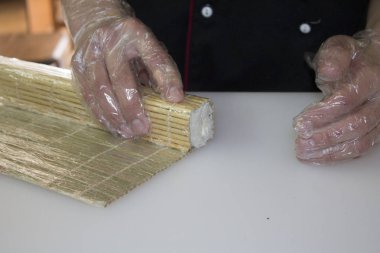 Şef bambu hasırla suşi yapıyor.